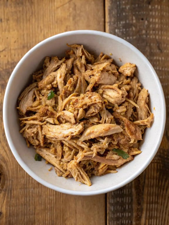 chicken carnitas recipe served in a bowl with rice, beans, and fresh toppings