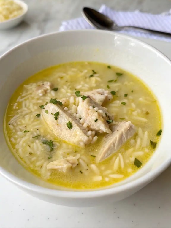 Greek lemon chicken soup served in a bowl with fresh dill garnish