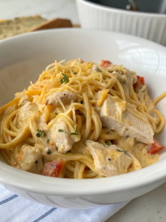 A beautifully plated serving of chicken spaghetti casserole with a side salad