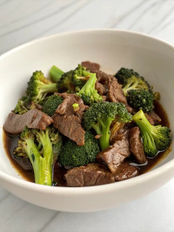beef and broccoli beautifully plated with steamed rice and garnishes