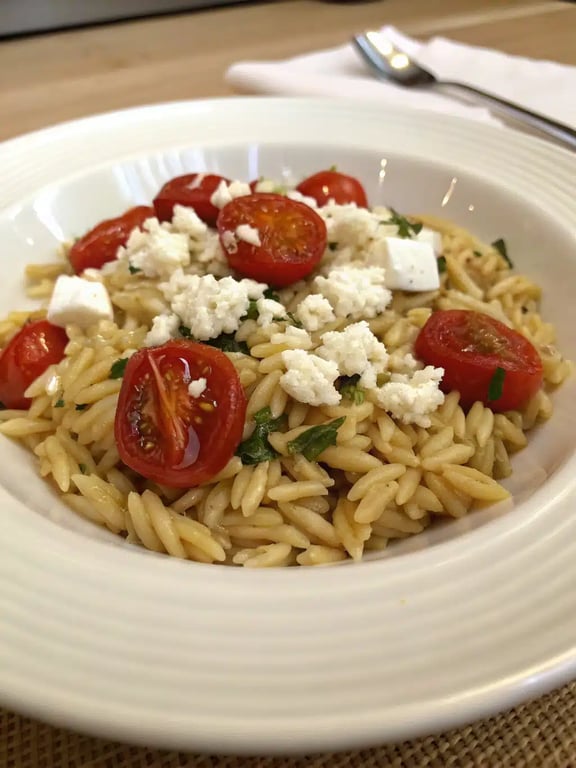 orzo dinner recipe beautifully plated with fresh herbs and lemon wedge