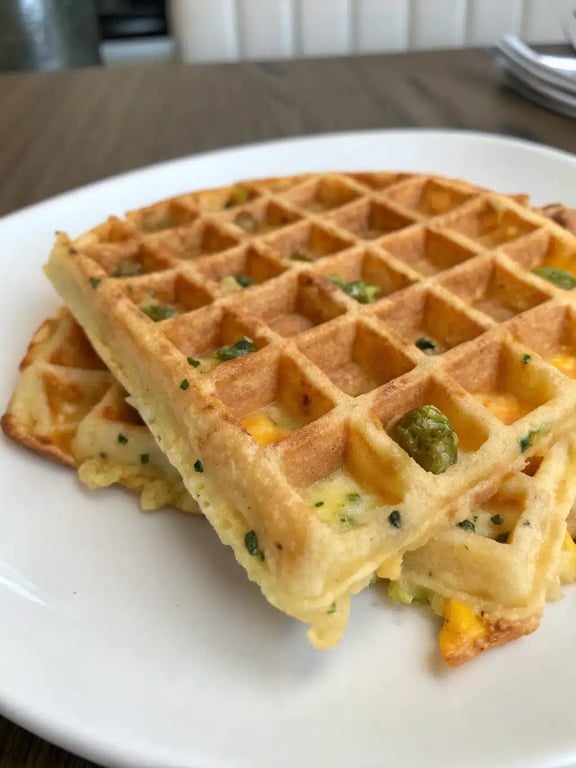 A plated serving of cheddar jalapeño waffles with eggs and avocado