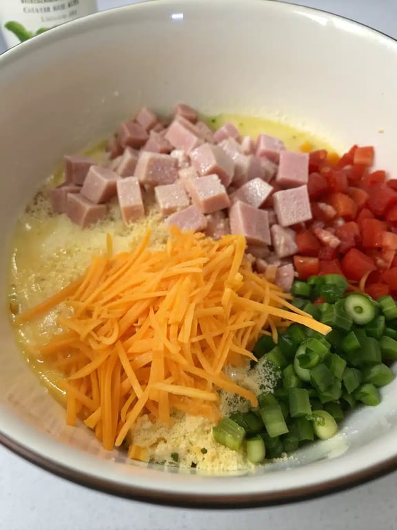 Step 4 for egg muffins recipe — pouring egg mixture into a muffin tin