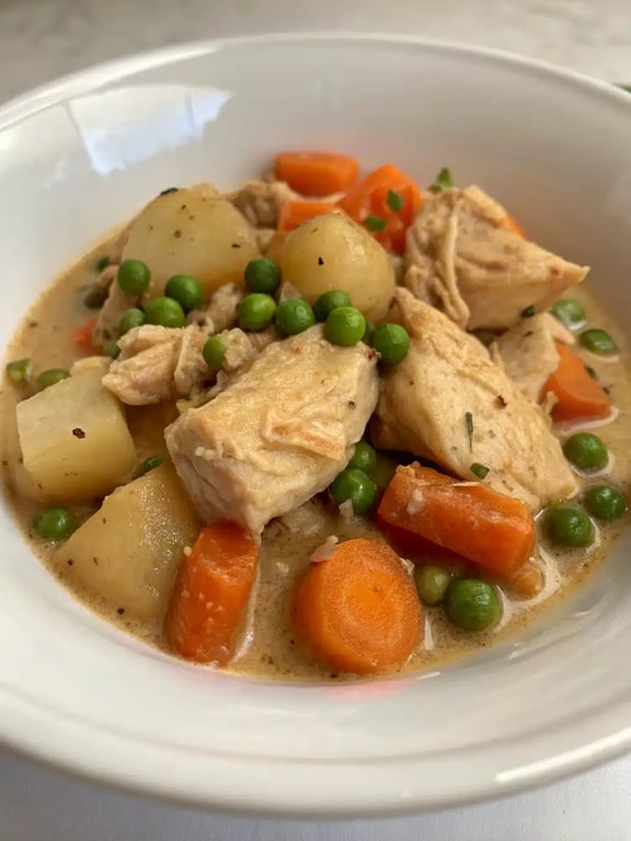 slow cooker chicken stew served in a bowl with a side of bread