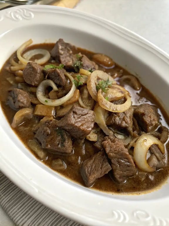 beef tips slow cooker plated elegantly over creamy mashed potatoes with a side of green beans