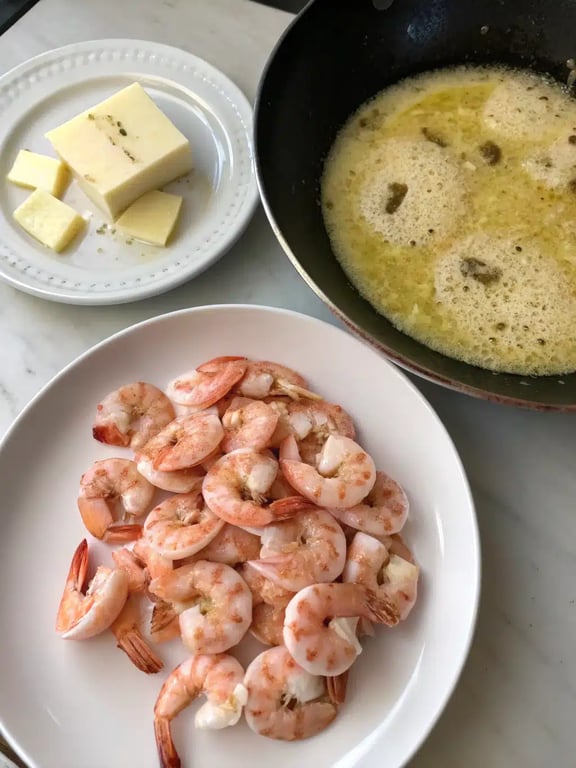 Step 4 for creamy shrimp pasta — creamy sauce simmering in a pan