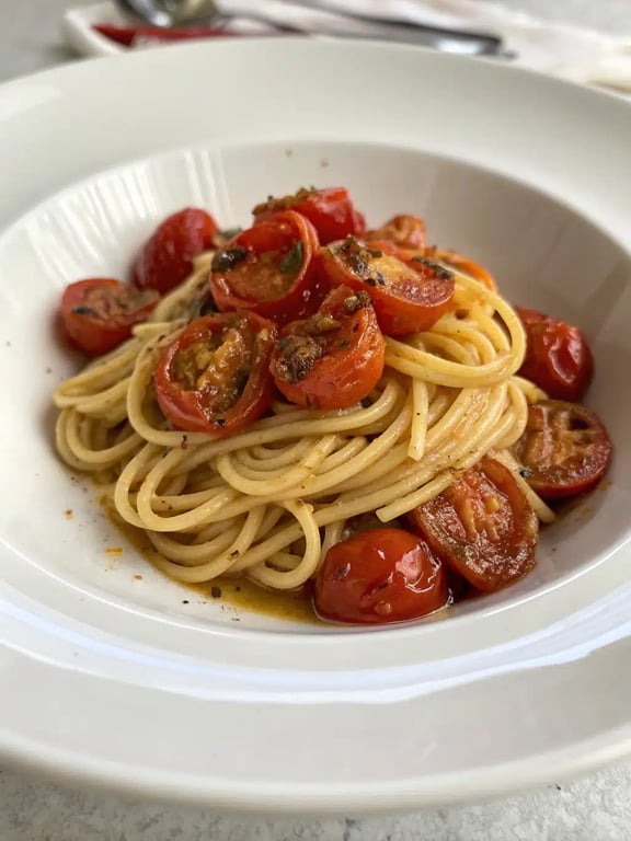 roasted tomato pasta beautifully plated with a side salad and bread
