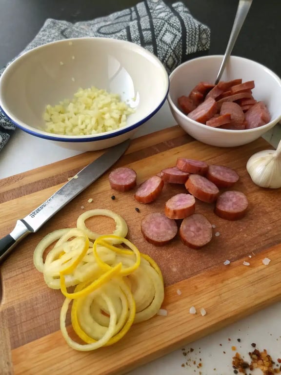 Step 2 for smoked sausage pasta — browning sliced sausage in a skillet