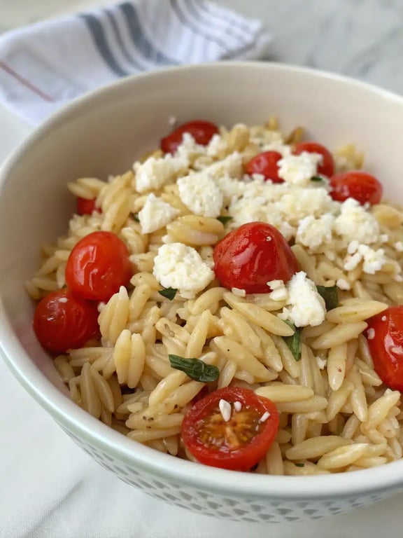 veggie orzo recipe beautifully plated with fresh herbs and feta cheese