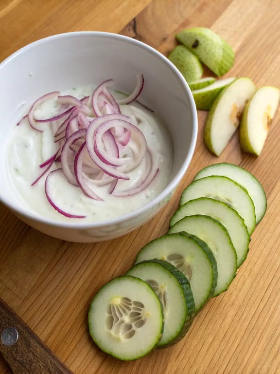 Step 4 for cucumber apple salad, combining crisp apple and cucumber slices with dressing