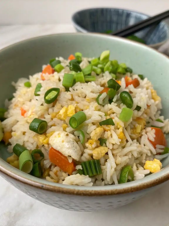 egg fried rice plated beautifully with chopsticks and garnishes
