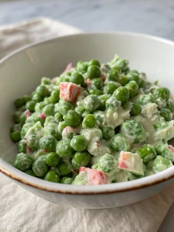 English pea salad beautifully plated with grilled chicken and fresh herbs