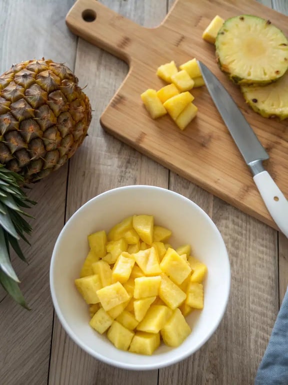 Step 2 for pineapple fried rice showing onions, peppers, and carrots stir-frying in a wok