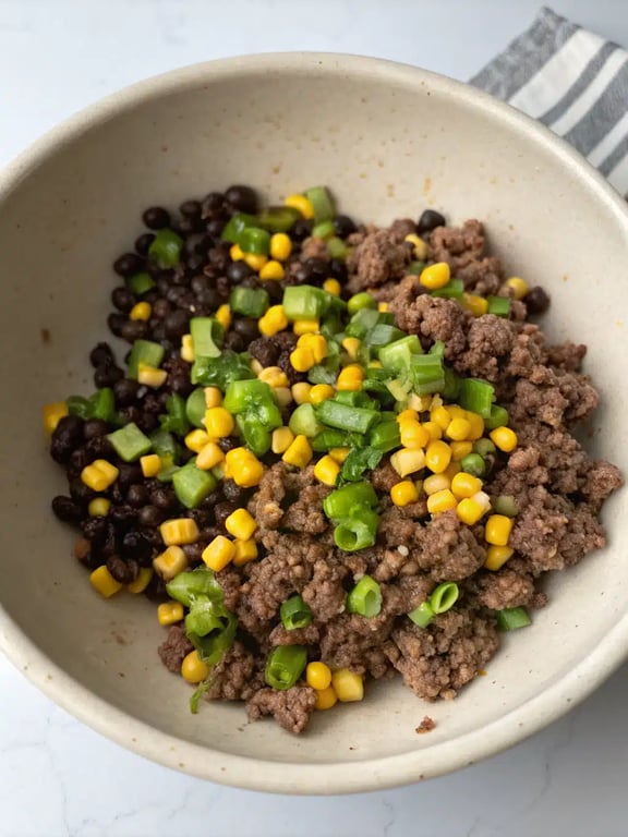 Layering the beef mixture and cheese in the baked burrito casserole dish