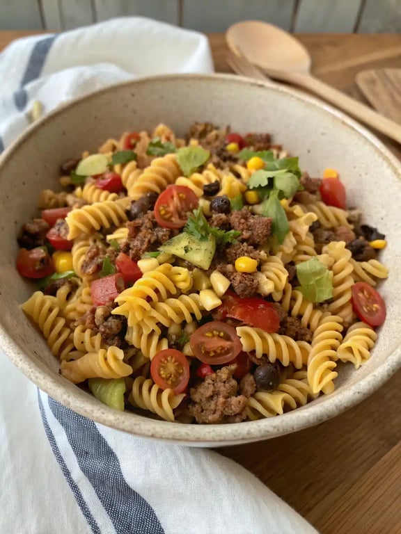 taco pasta salad beautifully plated with lime wedge and cilantro garnish