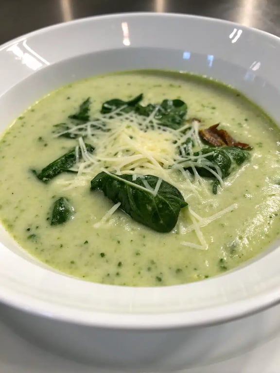 creamy Tuscan artichoke soup served in a bowl with crusty bread on the side