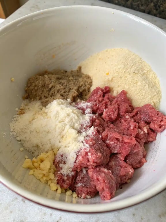 Step 2 for Italian meatball recipe — gently mixing the meatball ingredients in a bowl