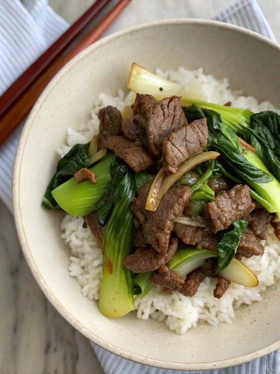 bok choy beef stir fry plated beautifully with white rice and garnishes