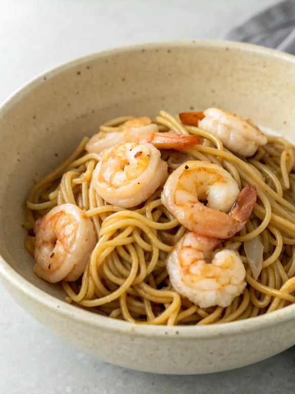 shrimp lo mein beautifully plated in a bowl with chopsticks