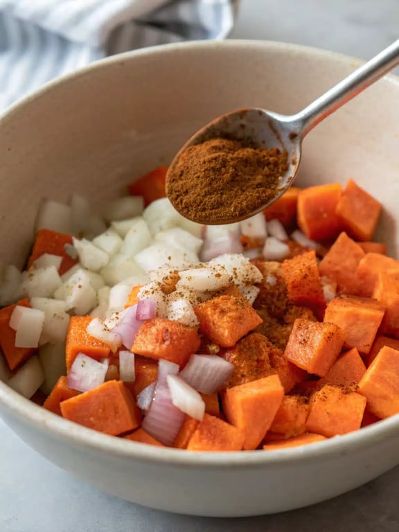 Step 4 for black bean sweet potato soup — using a masher to thicken the soup