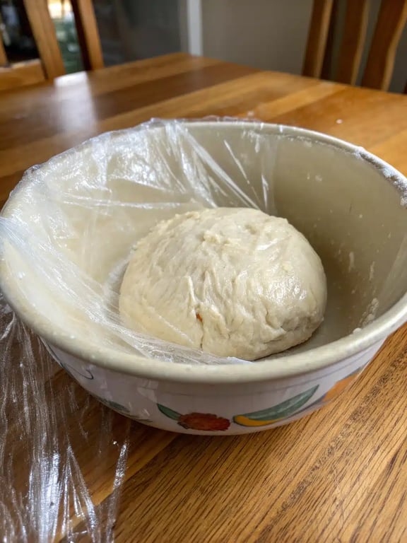 Step 4 for no rise pizza dough — dough resting in an oiled bowl