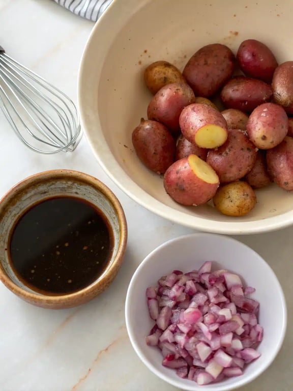 Gently tossing the dressed potatoes with red onion in a large mixing bowl