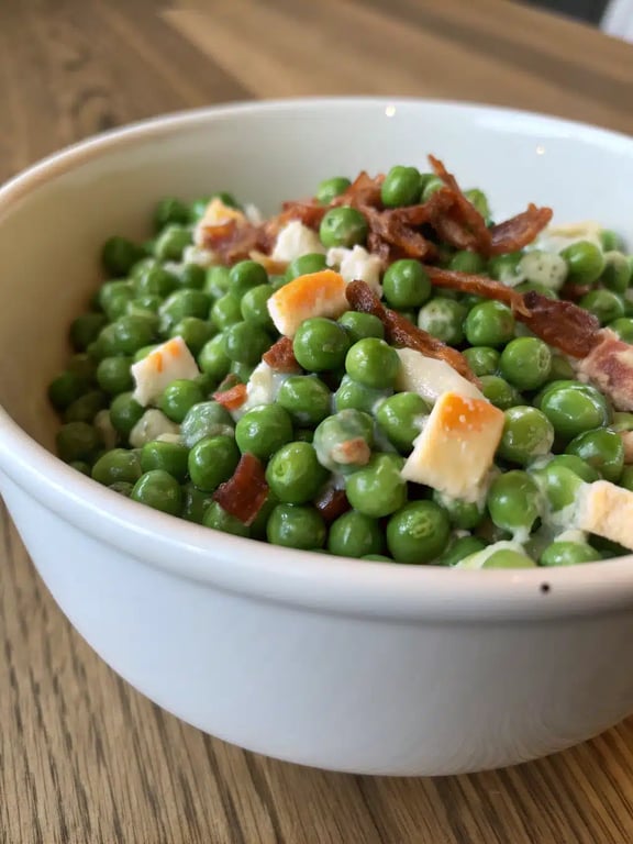 English pea salad recipe beautifully plated on a picnic table with other sides