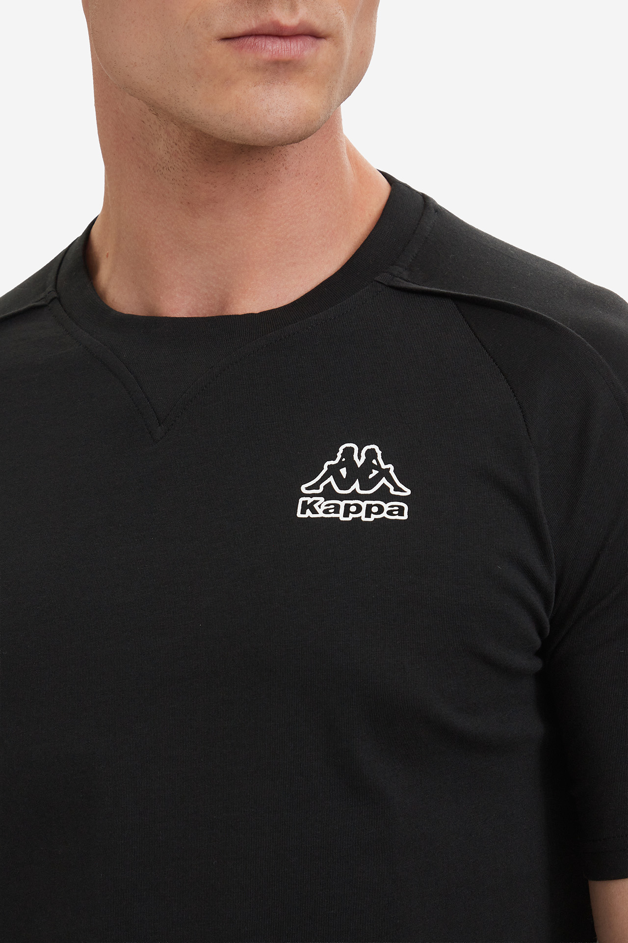 Zbliżenie na górną część koszulki z widocznym logo na piersi.