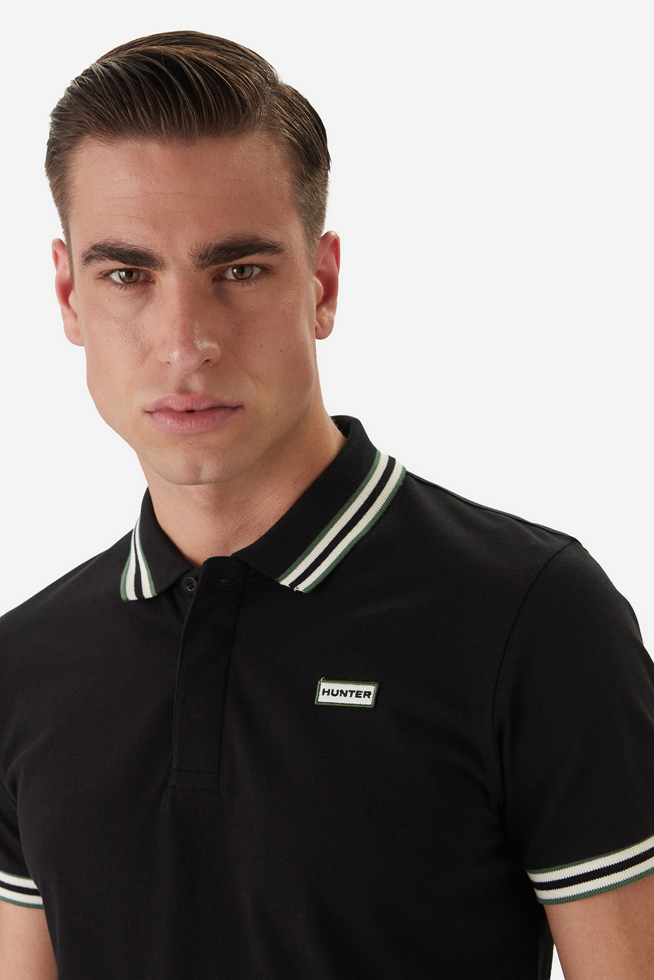 Zbliżenie na górną część sylwetki modela w koszulce polo.