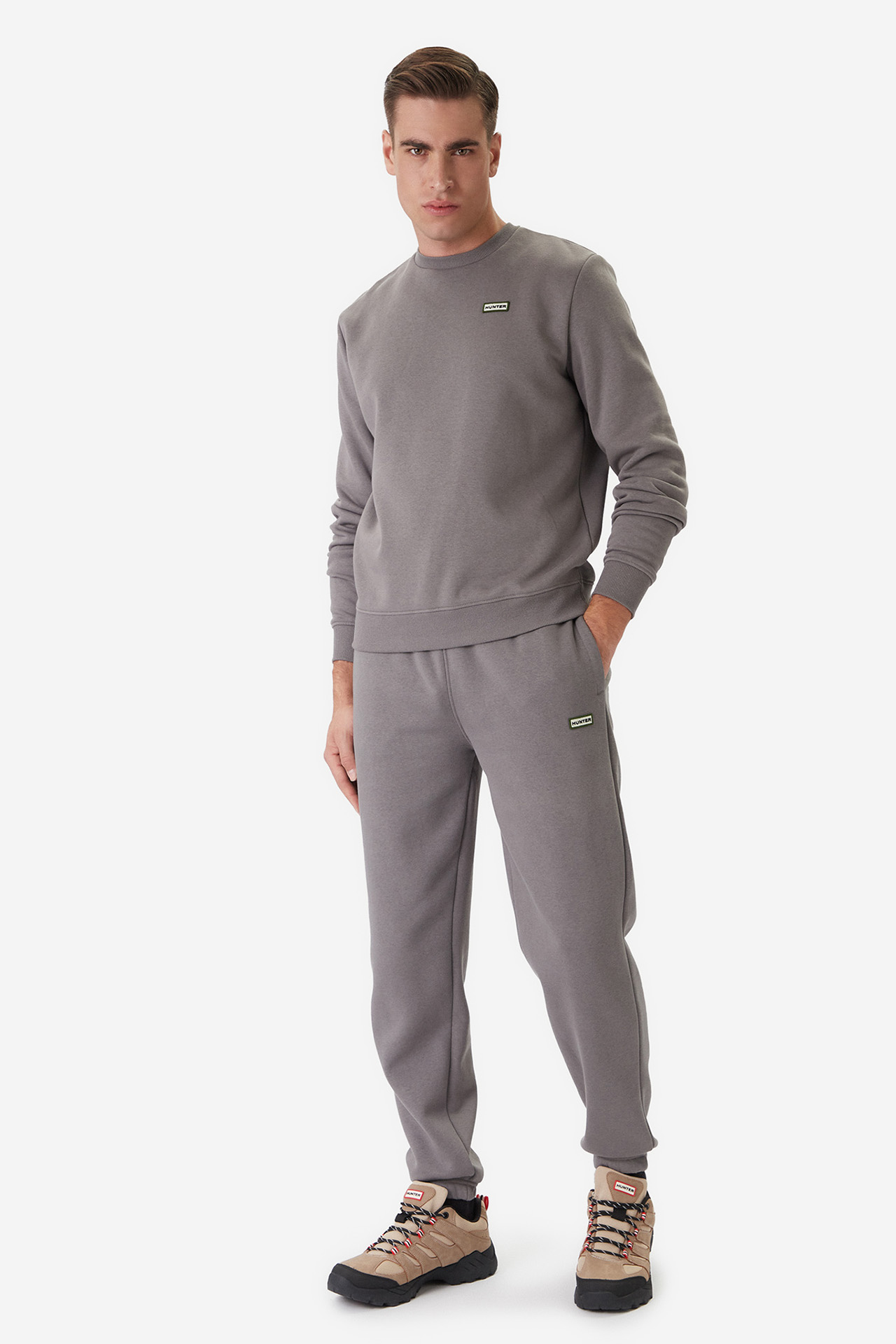 Model w dresowym komplecie, ujęcie całej sylwetki z przodu.