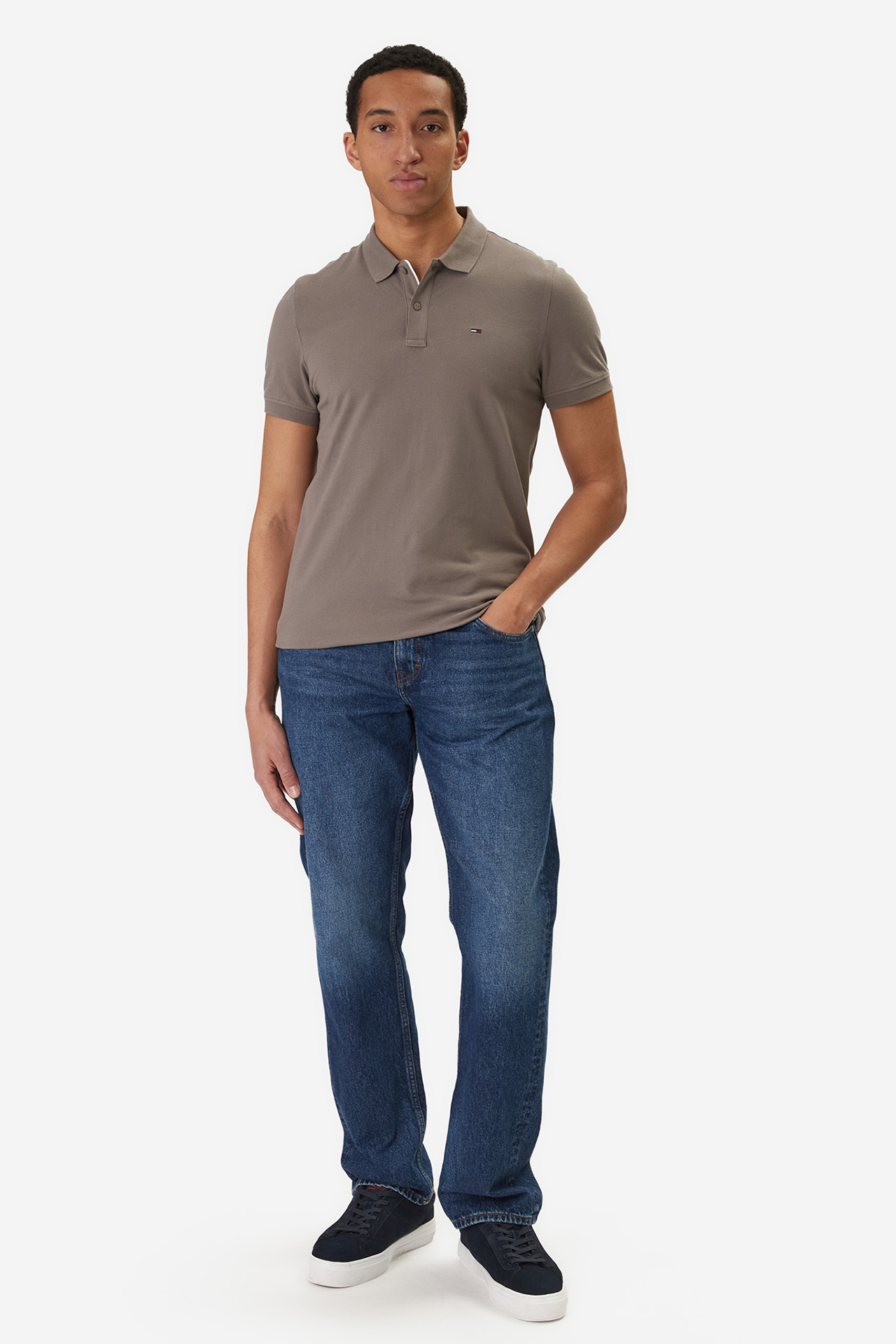 Model w koszulce polo i dżinsach, ujęcie całej sylwetki od przodu.