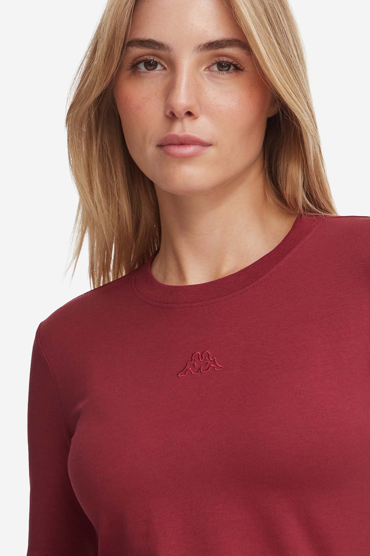 Zbliżenie na górną część bluzki na modelce, widoczny dekolt pod szyję.