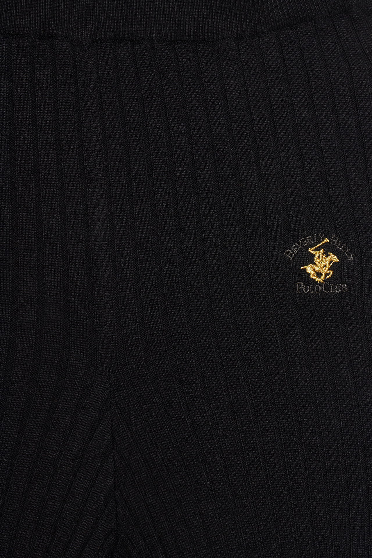 Zbliżenie na górną część spodni z widocznym logo.
