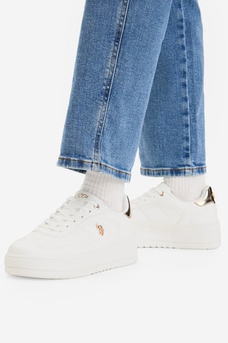 Model prezentujący buty na stopach, ujęcie na dolną część nóg.