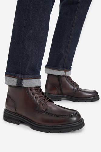 Model prezentuj?cy sznurowane buty za kostk?, nogawki podwini?te u do?u.