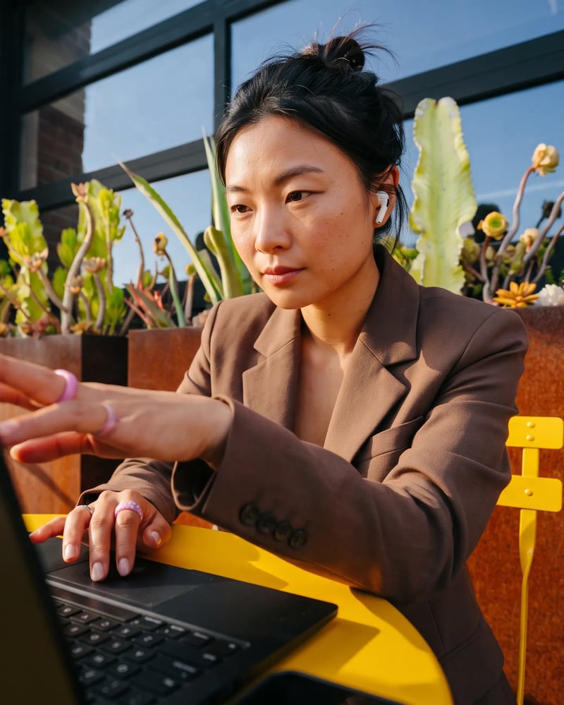 Kāsper creative working on a laptop on a sunny terrace