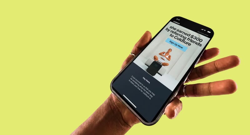 Coldture referral email on a phone held against a yellow background