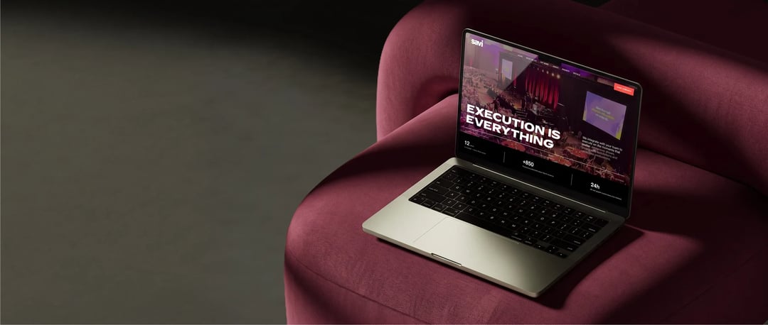 Savi website on a laptop resting on a burgundy armchair