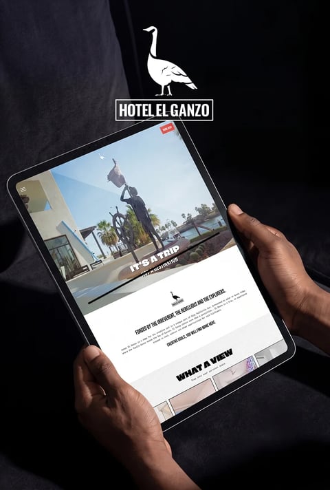Hotel El Ganzo website displayed on a tablet held in two hands
