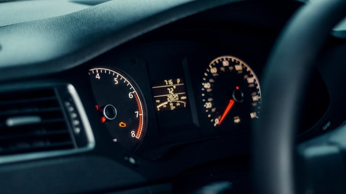 Přístrojová deska dieselového vozu se svítící kontrolkou motoru, symbol typický pro chyby systému SCR a AdBlue.