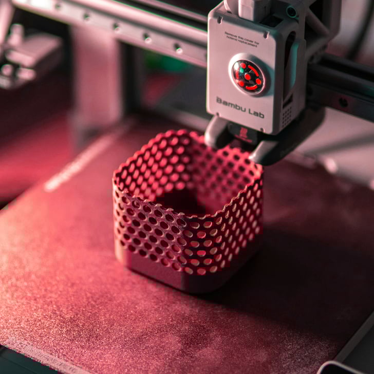 Moderní 3D tiskárna demonstrující přesnost aditivní výroby FDM vytvořením vlastního prototypu se složitým síťovým designem.