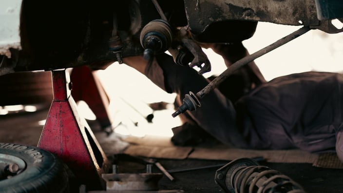Mechanik při diagnostice vozu v autoservisu.