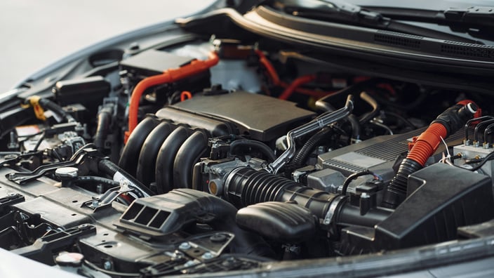 Моторный отсек современного автомобиля с открытым капотом и видимыми компонентами двигателя.