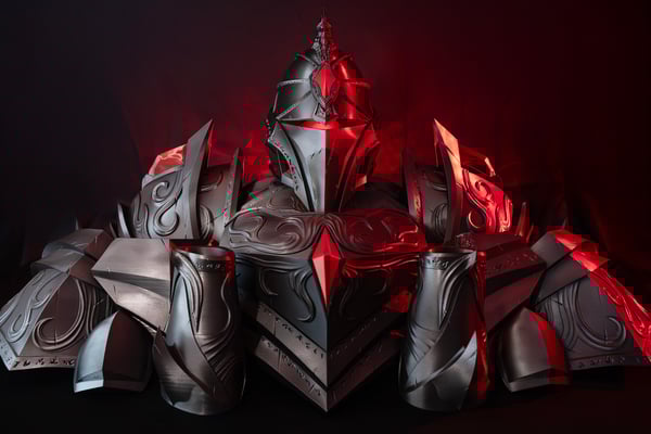 Kompletní a detailní brnění pro cosplay, 3D vytištěné v barvě kovu a zvýrazněné červeným světlem. Zobrazuje helmu, ramenní a hrudní pláty s ozdobnými rytinami a špičatými prvky. Ilustruje použití 3D tisku pro vytváření komplexních filmových rekvizit a cosplay kostýmů.