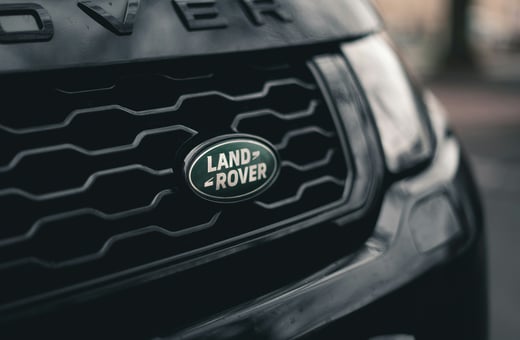 Эмблема бренда Land Rover на решётке радиатора роскошного внедорожника, символизирующая наш опыт в обслуживании премиальных полноприводных и внедорожных автомобилей.