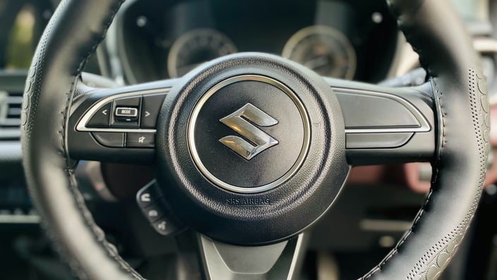 Крупный план многофункционального руля автомобиля Suzuki, для которого наш автосервис предлагает полный комплекс услуг по обслуживанию и диагностике.