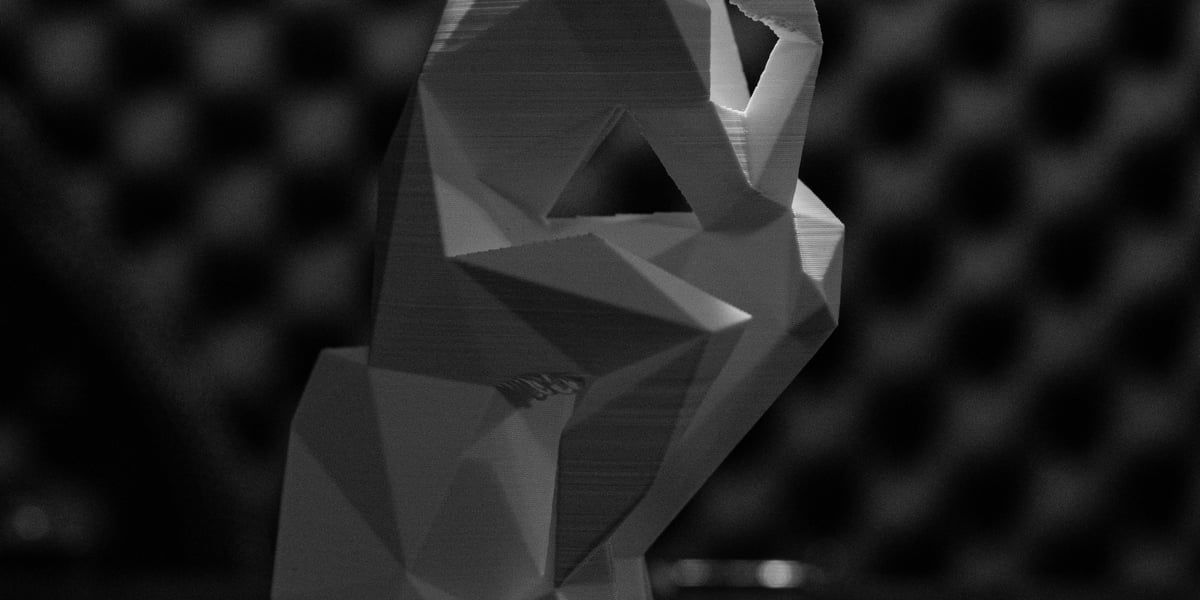 Detailní 3D výtisk umělecké figurky s viditelnou strukturou vrstev a geometrickými tvary.