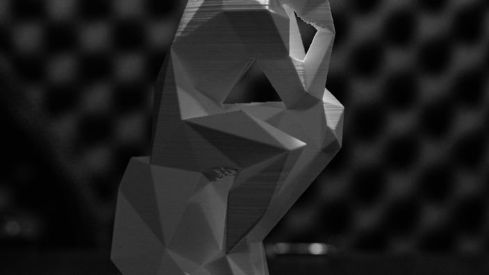 Detailní 3D výtisk umělecké figurky s viditelnou strukturou vrstev a geometrickými tvary.