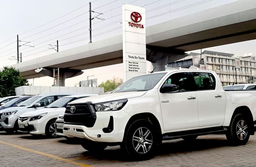 Белый пикап Toyota Hilux в дилерском центре, символизирующий надёжность, которую мы обеспечиваем благодаря нашим экспертным услугам по ремонту Toyota.