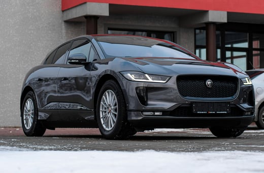 Полностью электрический внедорожник Jaguar I-Pace в зимнем пейзаже, указывающий на наши специализированные знания в области ремонта электромобилей и автомобилей класса люкс.